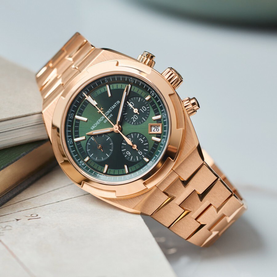 Overseas Chronograph in pink gold with a green dial lying on a book