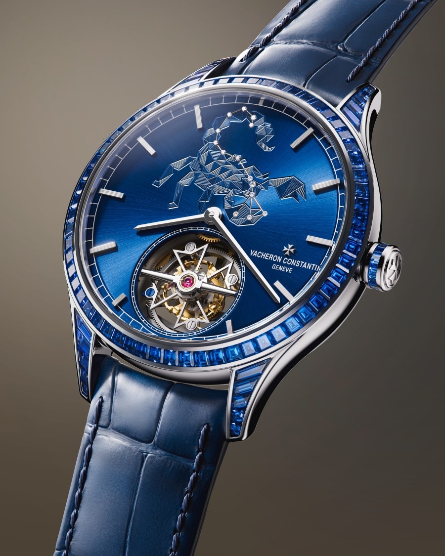 Métiers d'Art Tribute to The Celestial  Eine exklusive Armbanduhr mit blauem Zifferblatt mit Skorpionmotiv und einem raffinierten mechanischen Uhrwerk, das durch ein offenes Fenster sichtbar ist.
